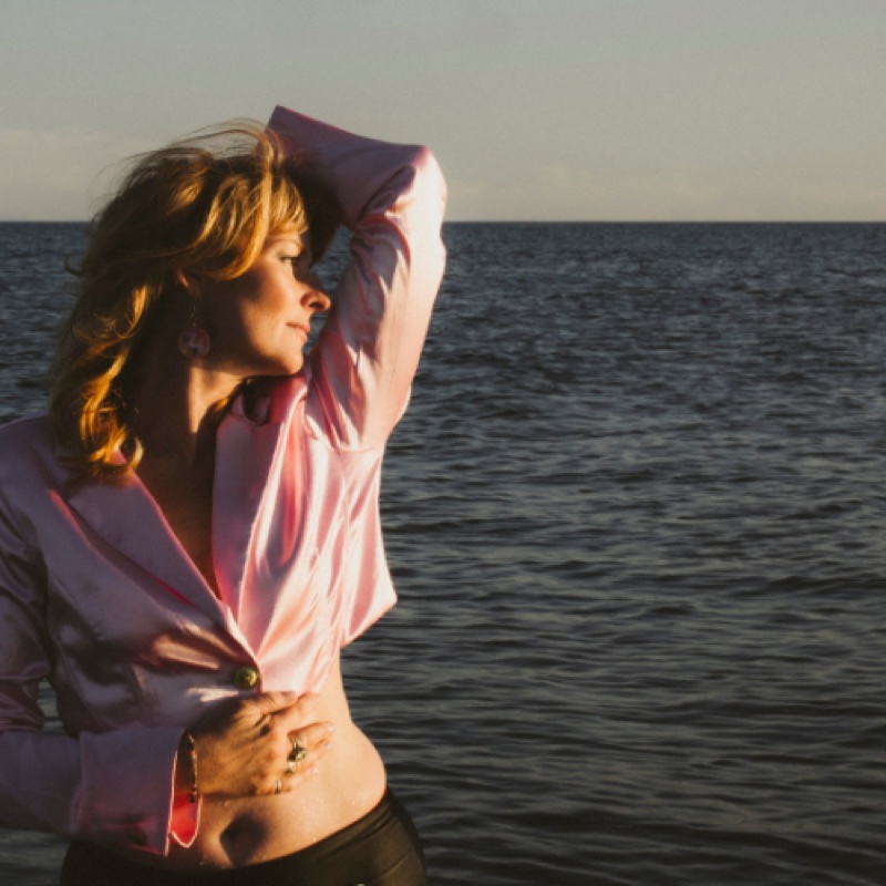 Jenn Grant, standing in the sea in a pink shirt.
