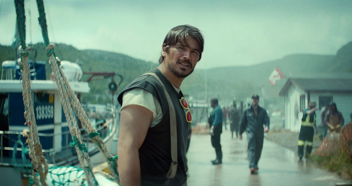 Josh Hartnett on a rainy wharf in a Newfoundland outport, in a still from Below. Photo: Netflix.